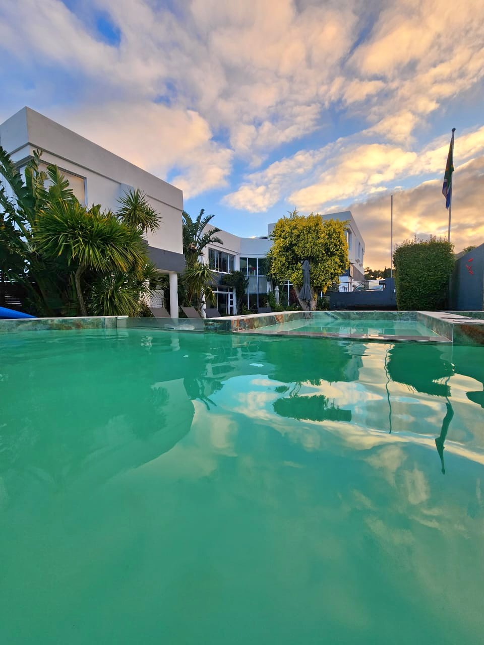 The swimming pool reflecting the sky and the guest house